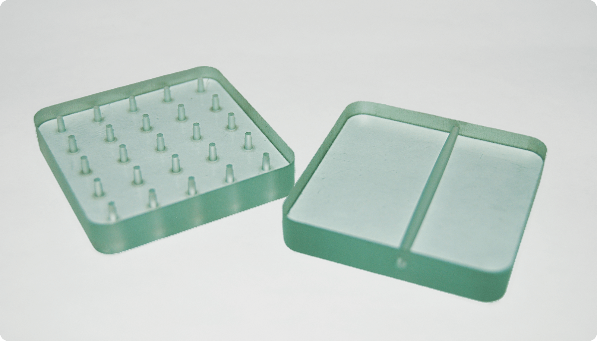 Two waterjet cut parts showing pierces in glass.