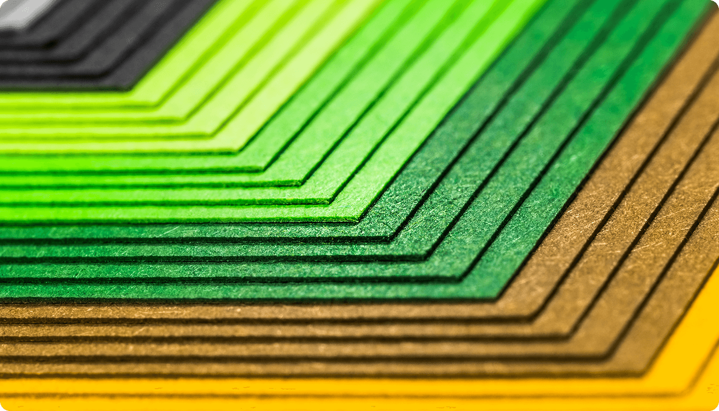 A creative photo of green, brown, and orange paper stacked and offset from each other.