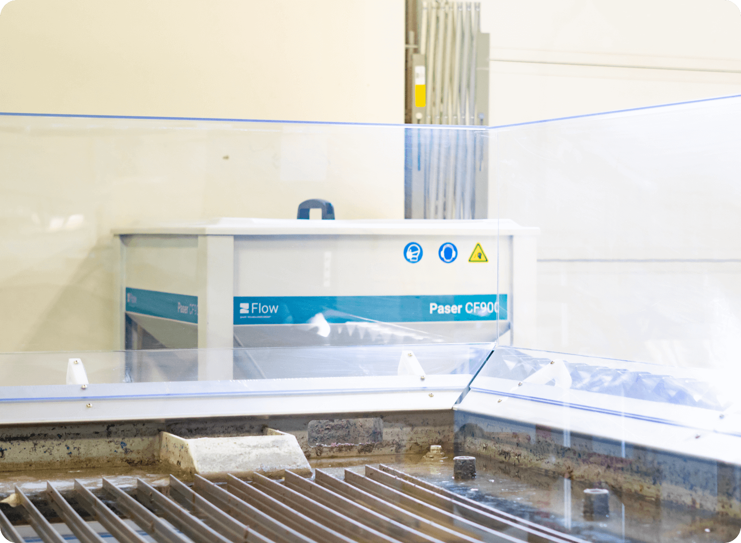 photo of the Paser CF900 shown behind a waterjet table and splash guards